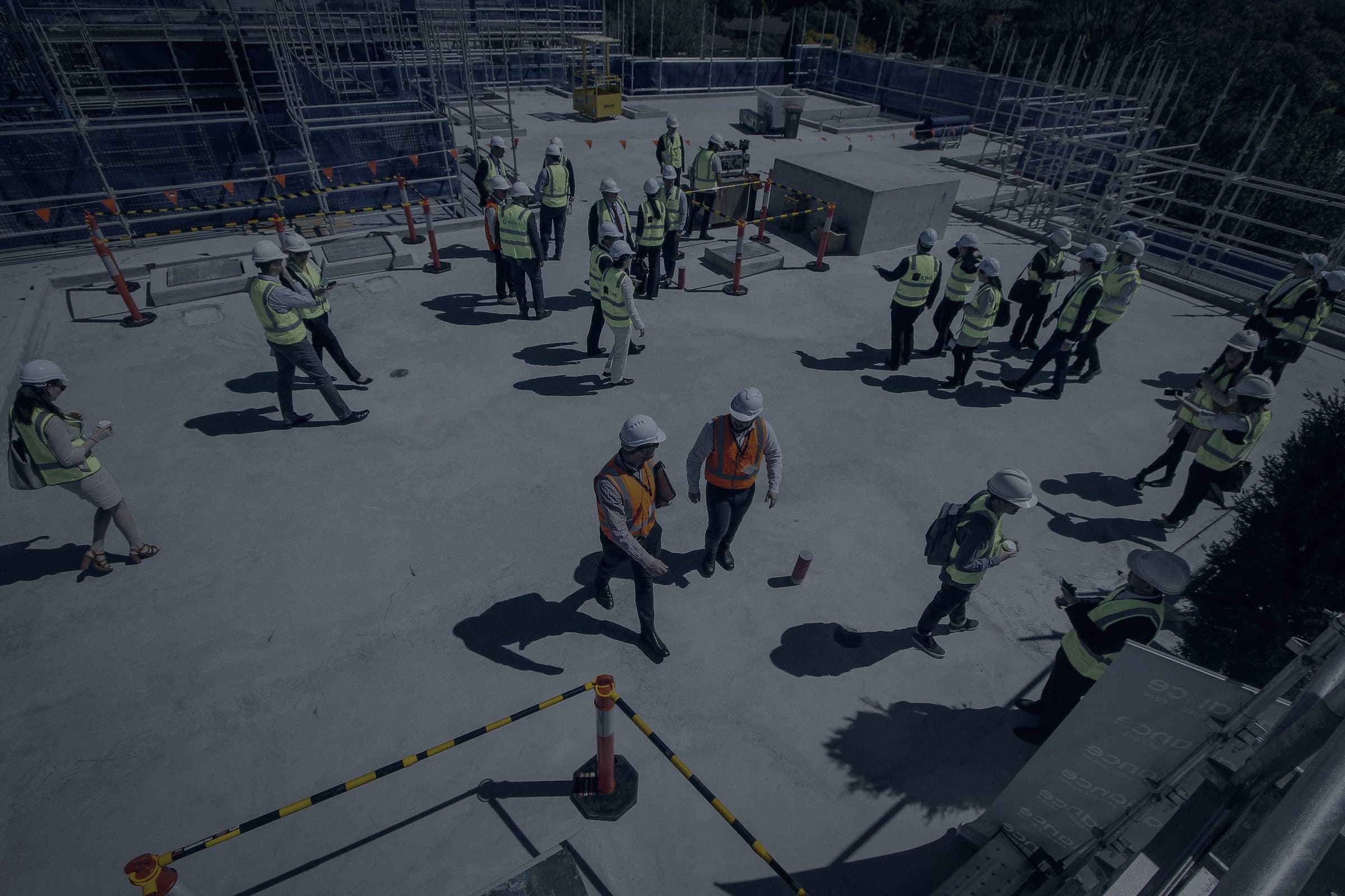 A crew in hi-vis and hard hats on a building slab, seen from above.